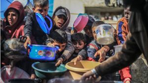 Palästinensische Kinder erhalten in einer Wohltätigkeitsküche zubereitete Lebensmittel. Offenbar beginnen die USA damit, Hilfsgüter über dem Gazastreifen abzuwerfen (Archivfoto). Foto: dpa/Mohammed Talatene