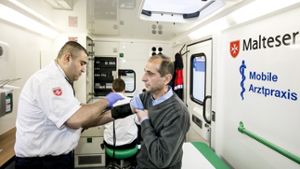 Khaled Shamsi misst den Blutdruck von Jamal Aldieen. Sowohl der Arzt als auch der Patient stammen aus Syrien – und treffen sich auf einem Parkplatz Foto: Lichtgut/Horst Rudel