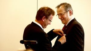 Johannes Schmalzl (li.) steckt Wolfgang Wanning das Verdienstkreuz an. Foto: Ott