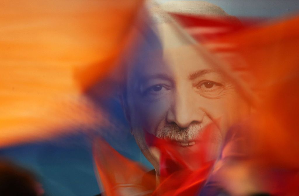 Anhänger schwenken nach der Wahl Fahnen mit dem Bild von Präsident Erdogan Foto: AP