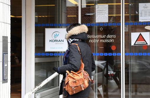 Eine Frau steht in Lyon vor einem Altenheim, in dem einige Menschen Opfer der Grippewelle wurden. Eine schwere Grippewelle in Frankreich bringt manche Krankenhäuser des Landes an ihre Kapazitätsgrenze Foto: AFP