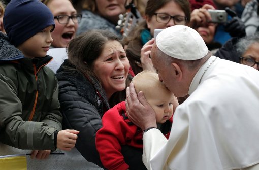 Der Papst küsst ein Kind aus der wartenden Menge. Foto: AFP