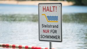 Ein Schild mit der Aufschrift „Halt Steilstrand nur für Schwimmer“ steckt im Silbersee in Hannover (Niedersachen). Ein heißer Sommertag am See macht viel mehr Spaß, wenn man richtig gut schwimmen kann. Foto: dpa