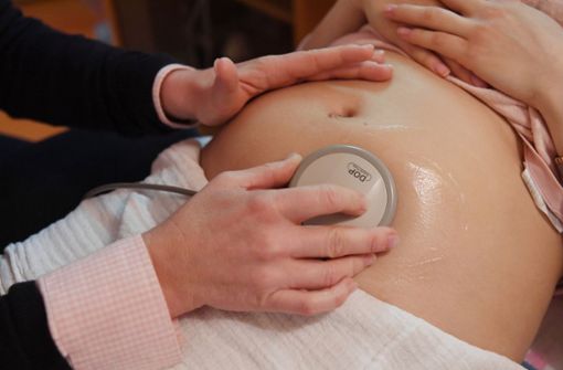 Eine Hebamme beim Überprüfen der Herztöne eines Babys im Mutterleib. Foto: dpa