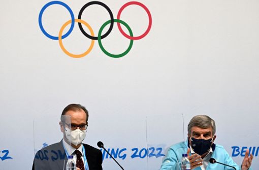 IOC-Sprecher Mark Adams (links, mit Thomas Bach) rief alle Beteiligten zur Ruhe im Dopingfall auf. Foto: AFP/ANNE-CHRISTINE POUJOULAT