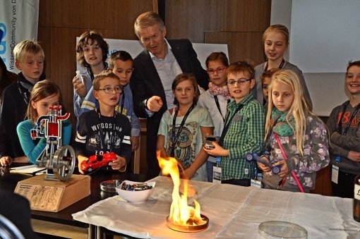 Feuer und Flamme für das Auto: Thomas Weber mit Kindern der Kinder-Uni. Foto: Linsenmann