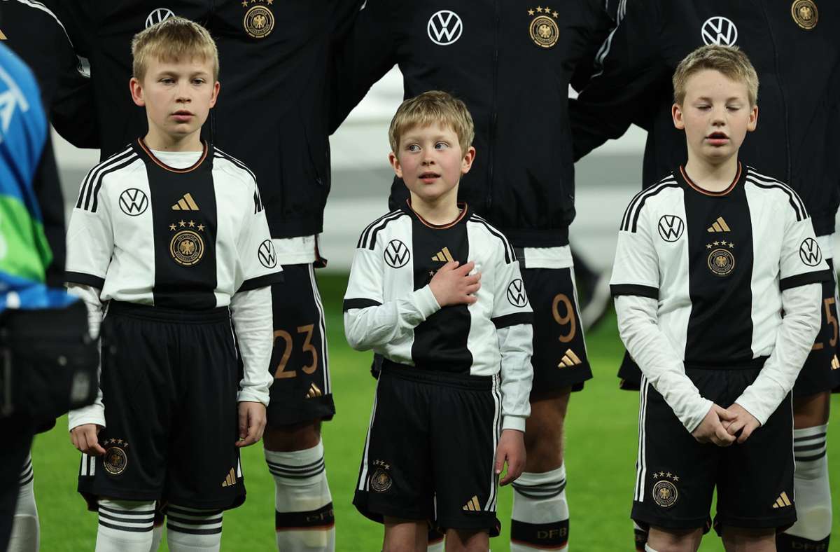 Einlaufkinder singen die deutsche Nationalhymne.