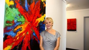 Ingrid Gunst vor einem ihrer Lieblingsbilder: Die Hobbymalerin bedient sich mit Vorliebe kräftiger, ausdrucksstarker Farben. Foto: Rebecca Stahlberg
