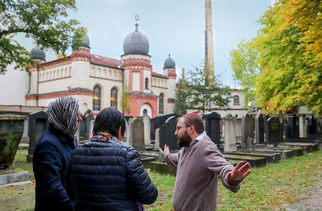 Mitglieder der Jüdischen Gemeinde  Halle unterhalten sich auf dem jüdischen Friedhof  mit einer Journalistin. Foto: dpa/Woitas, Gollnow