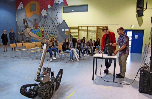 Heiko Helble (rechts) zeigt einem Schüler, wie der bei Rettungseinsätzen verwendete Roboter bedient wird und welche Funktionen er hat. Foto: Ayca Gürev