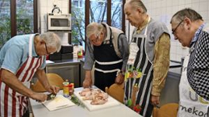Thomas Pfeiffer (links) zeigt und erklärt den Kochkursteilnehmern jeden einzelnen Arbeitsschritt. Foto: Elke Hauptmann