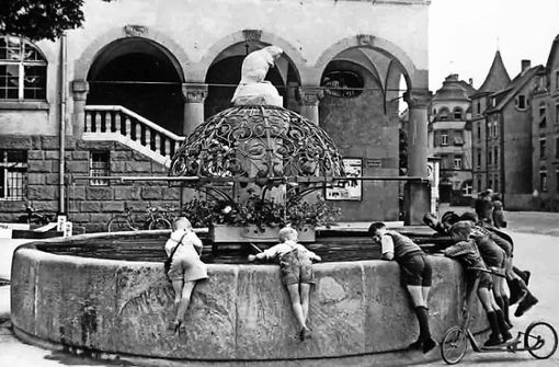 Kinder im Lederhosen-Look lehnen sich über den Biberbrunnen.  Lange haltbar sollte   das gute Stück damals sein. Deshalb wurde es auch regelmäßig mit Fett  eingerieben. Foto: privat