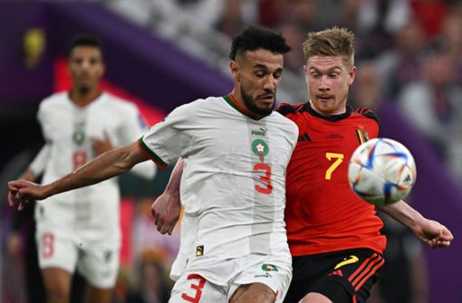 Marokkos Bayern-Profi Noussair Mazraoui (li.) gegen Belgiens Kevin De Bruyne – auf eines dieser beiden Mannschaften könnte das DFB-Team im Achtelfinale treffen. Foto: AFP/Manan Vatsyayana