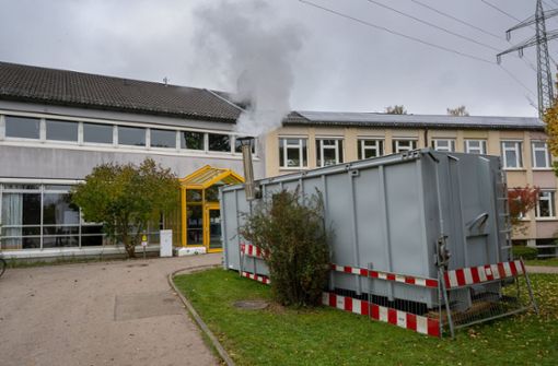 Wasserdampf steigt vor der Schule in Stadtbergen aus dem Schornstein eines Containers, in dem sich  eine mobile Hackschnitzel-Heizung  befindet. Foto: dpa/Peter Kneffel