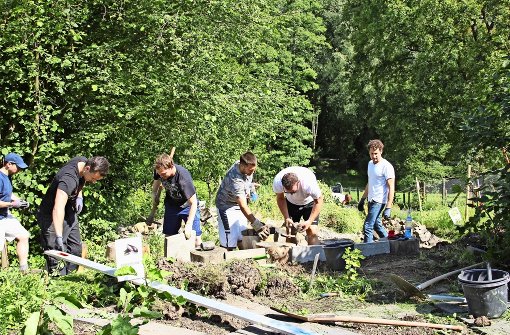 Die freiwilligen Helfer hatten am vergangenen Freitag alle Hände voll damit zu tun, bei den Gartenfreunden aus Botnang eine Mauer zu bauen. Foto: Torsten Ströbele