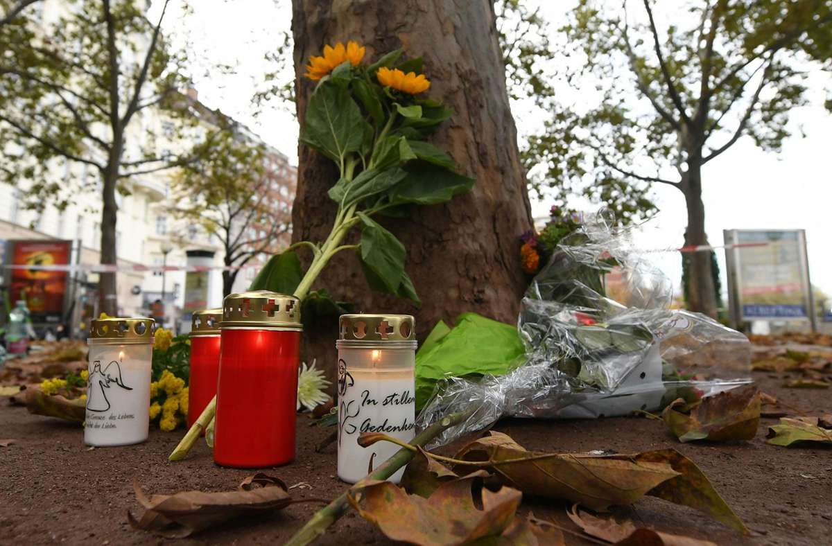 Kerzen und Blumen liegen im Bereich des Tatorts in Wien. Foto: dpa/Helmut Fohringer