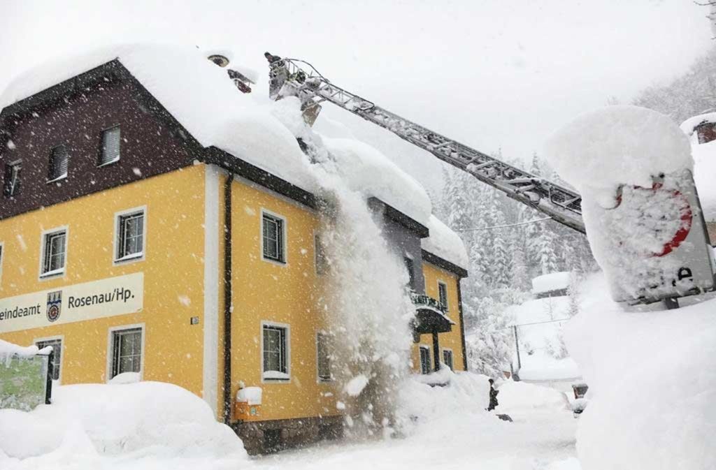 Die Schneemassen müssen von Häuserdächern entfernt werden, um das Einstürzen zu verhindern.
