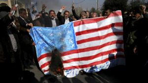 Iranische Demonstranten verbrennen am 05.01.2018 in Teheran (Iran) eine nachgebildete US-Fahne bei einer Demonstration gegen die regimekritischen Proteste der vergangenen Tage. Foto: dpa