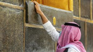 Ein Pilger berührt die Kaaba im  Innenhof der Heiligen Moschee. Foto: dpa
