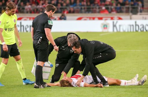 Borna Sosa vom VfB Stuttgart ist nach dem Foul des Wiesbadeners Chato (nicht im Bild) für einige Sekunden bewusstlos. Foto: Baumann