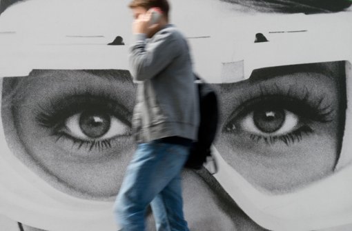 Im Fokus der US-Geheimdienste? Ein Passant geht in Stuttgart an einem Werbeplakat vorbei Foto: dpa