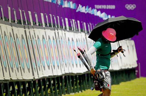 Beim Training schützt sich Bogenschützin Aida Roman aus Mexiko mit einem Schirm gegen die Sonne. Foto: dpa/Charlie Riedel
