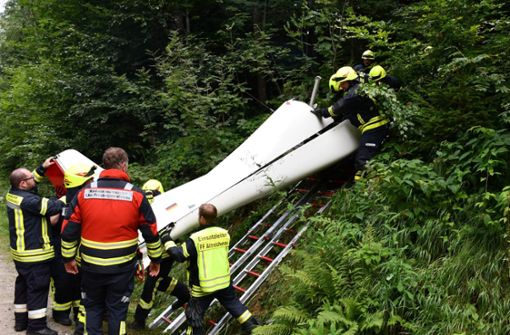 Feuerwehrleute bergen das Wrack des abgestürzten Ultraleichtflugzeugs aus dem Dickicht eines Waldes. Foto: dpa/Zema-Medien