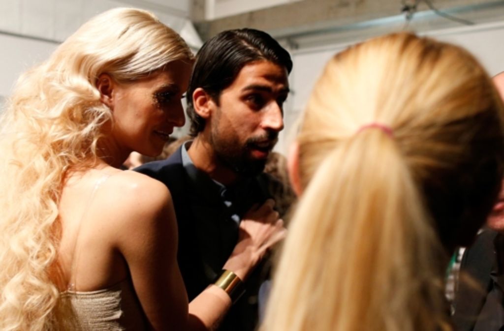 Promis auf der Fashion Week in Berlin: Lena Gercke hält sich hinter den Kulissen der Maybelline-Schau an ihrem Verlobten Sami Khedira fest.