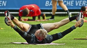 Auch dem Coach kann Bewegung nicht schaden: Christian Streich dehnt sich beim Training – nun wollen seine Spieler in der Europa League die Muskeln spielen lassen. Foto: dpa