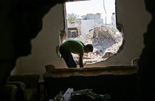 Israel und militante Palästinenser beschießen sich weiter: Dieser Palästinenser schaut in seinem zerstörten Haus im Westen von Gaza-Stadt nach Überbleibseln des Angriffs. Foto:  