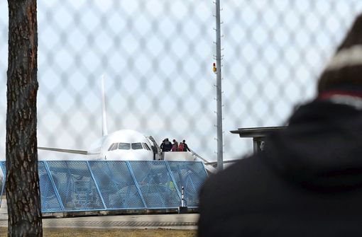Abgelehnte Asylbewerber steigen im Baden Airport in ein Flugzeug, das sie in ihre Herkunftsländer zurückbringt. Dabei werden sie von Polizisten begleitet. Foto: dpa