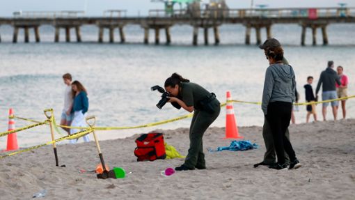 Eine Polizistin macht am Strand von Lauderdale-by-the-Sea Fotos vom Tatort. Foto: Mike Stocker/South Florida Sun-Sentinel/AP/dpa
