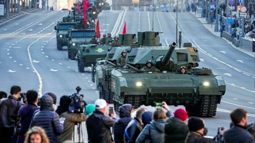 Zuschauer beobachten im Mai 2022, wie ein russischer T-14 Armata-Panzer (im Vordergrund) und andere gepanzerte Fahrzeuge auf der Twerskaja-Straße in Richtung Roter Platz rollen. Foto: Alexander Zemlianichenko/AP/dpa