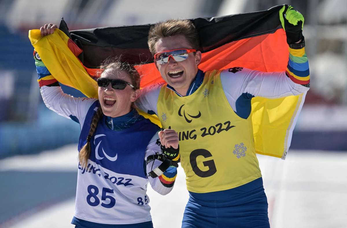 Die deutsche Leonie Maria Walter (links) und ihr Guide feiern den Sieg im Biathlon. Foto: AFP/MOHD RASFAN