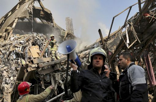 In Teheran steht zunächst ein Hochhaus in Flammen, dann bricht das 17-stöckige Gebäude zusammen und begräbt zahlreiche Feuerwehrleute unter sich. Foto: AP