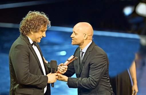 Aus der Hand des Schauspielers Jürgen Vogel nimmt Alexander Berner (links) den Deutschen Filmpreis für seine Cutter-Tätigkeit bei „Cloud Atlas“ entgegen. Foto: dpa