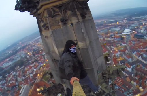 Lebensgefährliches Panorama über Ulm: Der Kletterer filmt sich selbst auf der Spitze des Ulmer Münsters. Foto: Screenshot „Grave Yard Kidz“
