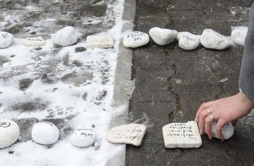 Eine Frau legt am 11. März 2010 eine beschriftete Stein bei der Gedenkfeier für die Opfer des Amoklaufs in Winnenden auf den Boden.  Foto: dpa