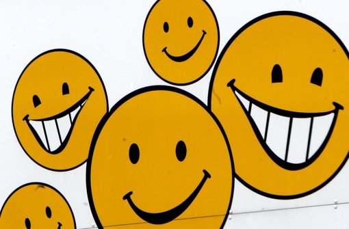 Lachende Gesichter auf einem Supermarktplakat: Einfach mal freundlich die Zähne zeigen Foto: dpa