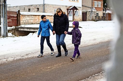 Helene Hördt geht mit zwei Kindern durch die verschneiten Straßen von Zsobok spazieren. Foto: Dominik Thewes