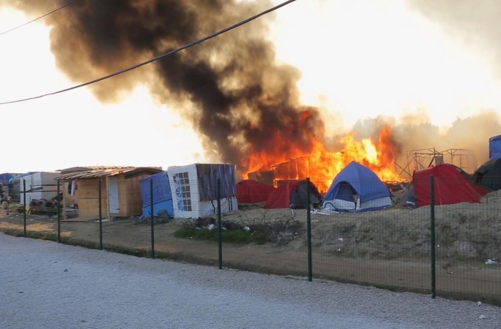 Rauch steigt über dem Flüchtlingslager in Calais in Frankreich auf. Hier ist es zu einer gewaltsamen Auseinandersetzung zwischen Flüchtlingen gekommen.