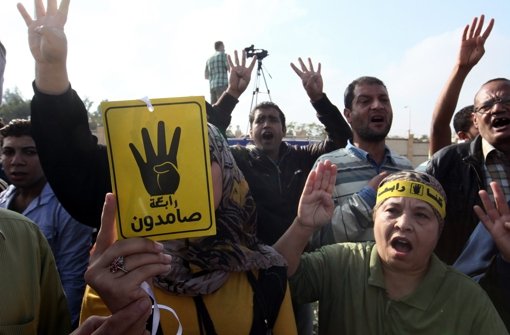 Vor der Polizeiakademie, in der der Prozess gegen Mohammed Mursi stattfindet, drängen sich Gegner und Befürworter des ehemaligen ägyptischen Präsidenten. Foto: dpa