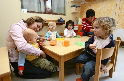 Erzieherinnen füttern die Kinder in einer Tageseinrichtung Foto: dpa