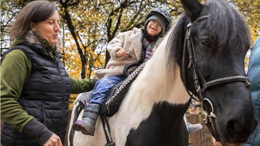 Pädagogin Kerstin Sieber (links) unterstützt Mariam bei ihrem Ritt auf Pony Levi. Foto: Lichtgut/Julian Rettig