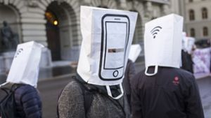 Die Einführung von 5G steht kurz bevor – doch unter die Euphorie mischt sich auch Zweifel: Aktivisten tragen in Bern Papiertüten auf dem Kopf, auf denen Mobiltelefone abgebildet sind, um vor dem Ausbau des Mobilfunknetzes zu warnen. Foto: dpa