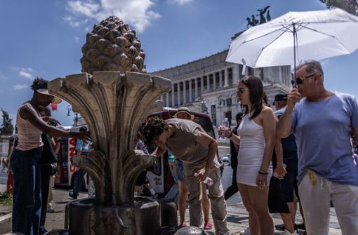 Touristen schwitzen in Rom. Foto: dpa/Oliver Weiken