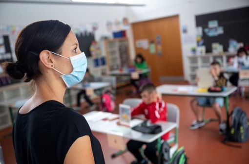 Eine Lehrerin steht mit Maske vor ihrer Grundschulklasse. Foto: dpa/Sebastian Gollnow