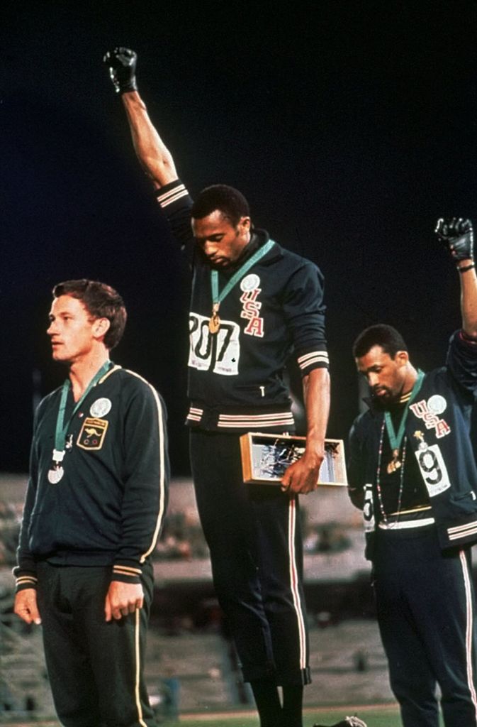 Die Black-Power-Faust:  Diese Geste der amerikanischer Sprinter Tommie Smith und John Carlos bei den Olympischen Spielen 1968 im Mexiko geht  um die Welt. Die beiden nutzen die Medaillenvergabe für einen stummen Protest für Rassengleichheit und mehr Bürgerrechte für Farbige. Der dritte Mann auf dem Podium, der Silbermedaillengewinner Peter Norman aus Australien, beteiligt sich an der Aktion. Aus Solidarität leiht  er sich den Anstecker einer schwarzen Menschenrechtsorganisation und trägt ihn stolz am Trainingsanzug.