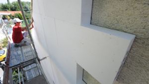 Gut isoliert, gut gespart: Ein Arbeiter befestigt Styroporplatten zur Wärmedämmung an einer Fassade Foto: dpa