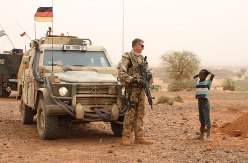 Die Bundeswehr im Auslandseinsatz: Ein deutscher Blauhelmsoldat unterhält sich während einer Patrouille in der Stadt Gao im Norden Malis mit einem Kind. Foto: dpa
